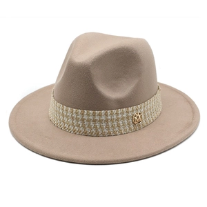 Detail of khaki wool fedora hat featuring a plaid ribbon and gold metal M logo charm