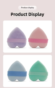 Macro detail of heart-shaped flocking makeup puffs with silk ribbons in soft pastel colors