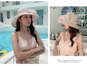 Detailed view of oversized floral organza sun hat on model by a summer pool