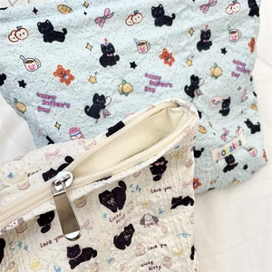 Detailed view of quilted makeup bag with cartoon patterns and silver metal zipper