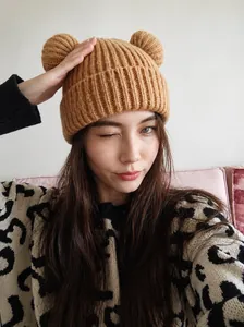 Close-up of warm brown knit beanie featuring cute 3D bear ears and thick ribbed texture