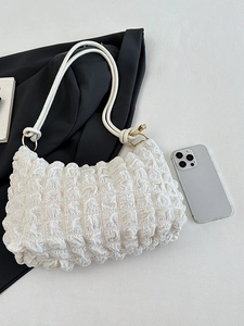 Minimalist white pleated shoulder bag with metallic ring and quilted cloud texture