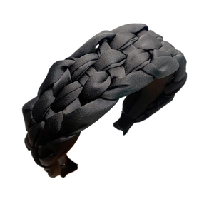 Detailed view of black braided satin headband with a glossy finish and texture