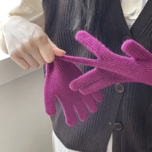Vista de detalle de los guantes de lana morada que muestra la elasticidad y textura suave