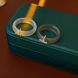 Detailed macro view of translucent chalcedony rings with silver cross charms on green leather