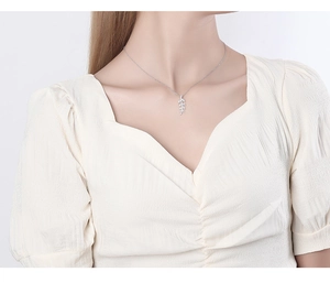 Close-up of S925 silver leaf pendant necklace on model with pavé cubic zirconia