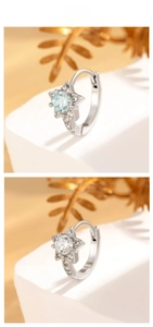 Detailed view of star-shaped silver earrings with blue and white zircon stones