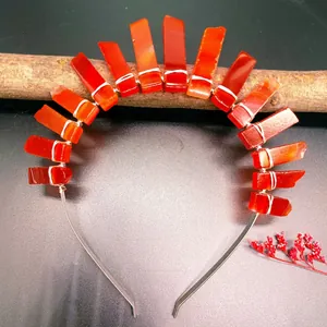 Macro shot of red raw crystal bohemian crown with silver wire wrapping on wood base