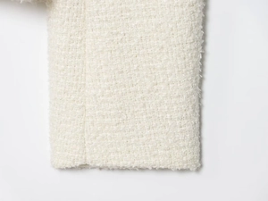 Gros plan sur la texture du tissu en tweed blanc crème avec détails de tissage raffinés