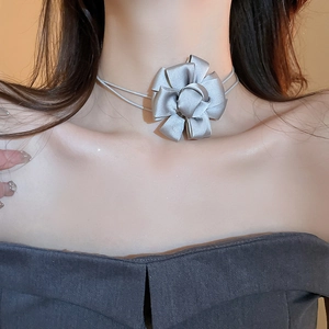 Close-up of grey fabric flower choker with delicate silk ribbon ties on model neck