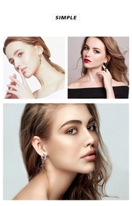 Close-up of cross dangle earrings in gold, silver, and black stainless steel finishes
