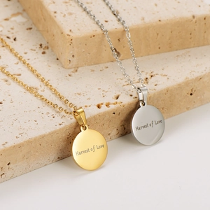 Gold and silver stainless steel harvest of love pendant necklaces on stone display