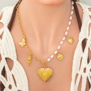 Detail of 18k gold heart locket necklace with asymmetrical pearls and floral pendants