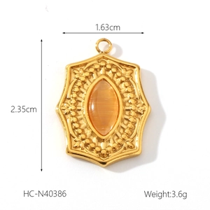 Detail of a gold moon star pendant with an oval orange cat eye stone and beaded border