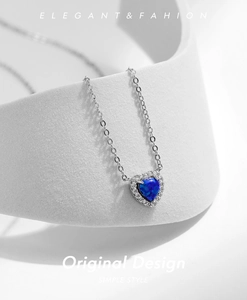 Gros plan du collier cœur en argent 925 avec opale bleue et halo de diamants