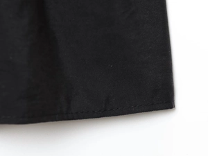 Détail de la texture en sergé et des coutures sur les bords d'un caraco noir élégant