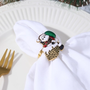 Golden Santa Claus climbing chimney napkin ring on a white linen napkin and ceramic plate