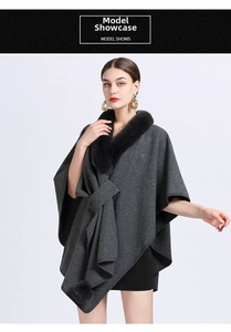 Detail of dark grey knit poncho with black faux fur collar and elegant waist tie design