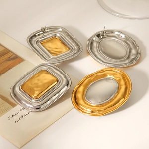 Detail of hammer-textured gold and silver mixed metal earrings with geometric design