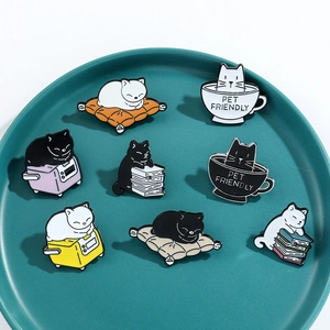 Detailed close-up of 8 cute cartoon cat enamel pins displayed on a ceramic plate