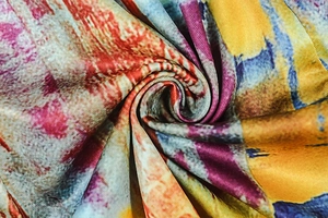 Vue macro détaillée du tissu imprimé abstrait coloré avec des plis en spirale