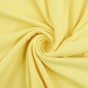 Vue détaillée du tissu en maille jaune clair avec un drapé doux et une texture fine
