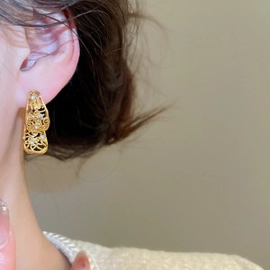 Détail de boucles d'oreilles vintage en goutte d'or avec pompon évidé et oxydes de zirconium