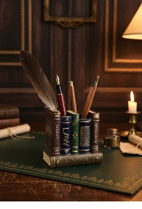 Detail of vintage book-shaped resin pencil holder with gold embossed spines for desk storage