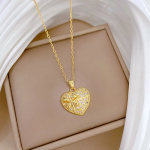 Détail du pendentif cœur doré avec design de nœud et cristaux de zircone cubique scintillants
