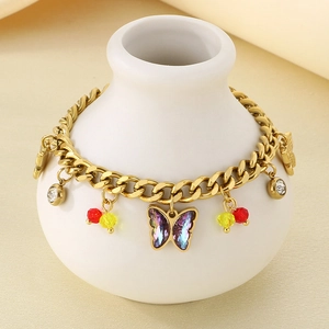Detailed shot of golden chain bracelet with purple butterfly and rhinestone charms