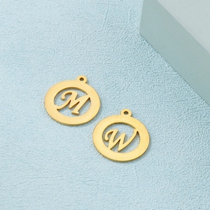 Golden stainless steel round hollow pendant with letters M and W on blue background