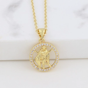 Macro shot of gold zodiac necklace with Virgo pendant and cubic zirconia on marble