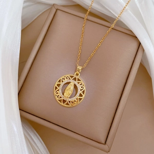 Close-up of golden portrait pendant necklace with zircon crystals on a luxury gift box