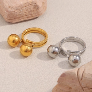Detail of minimalist double-band rings with spheres in 18K gold and silver finishes
