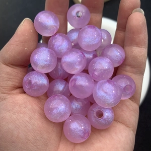 Macro shot of purple glitter beads for jewelry making showing fine sparkles and thread hole