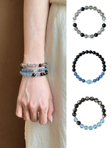 Detail of natural moonstone and obsidian beaded bracelets with silver hollow spacer beads