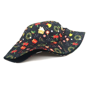 Close-up of black bucket hat with festive Christmas prints of bells and flowers