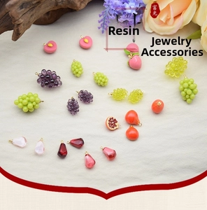 Detailed view of colorful fruit resin charms with metal loops for DIY jewelry making