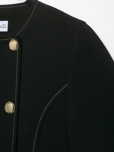 Detail of black double-breasted blazer with gold buttons and contrast brown stitching