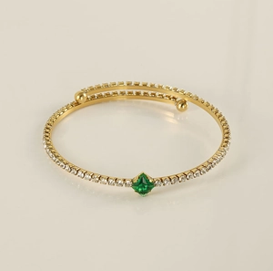 Detailed view of 18K gold-plated bangle with green square gemstone and zircon pavé