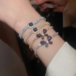 Détail de bracelets papillon en zircon avec pierres violettes portés au poignet féminin