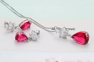 Détail macro du collier couronne en argent et parure de boucles d'oreilles rubis poire