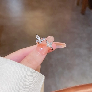 Detail of zircon butterfly ring with asymmetric double butterfly and open band design