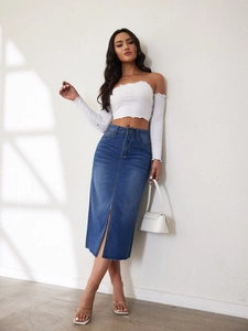 Detail van blauwe denim midi-rok met voorsplit en een off-shoulder gebreide damestop