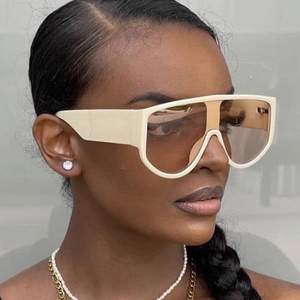 Fashionable oversized cream shield sunglasses with brown gradient lenses shown on a model