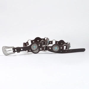 Detail of bohemian leather belt with turquoise inlay and silver carved metal medallions