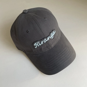 Close-up of deep gray cotton baseball cap featuring Hiranga letter embroidery detail