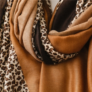 Detailed view of the leopard print scarf with gold foil accents and soft fabric texture