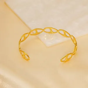 Elegant gold open cuff bracelet with anchor link chain design on satin backdrop