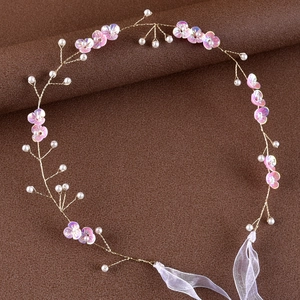 Detail of handmade bridal headband with pink resin flowers, white pearls and gold wire